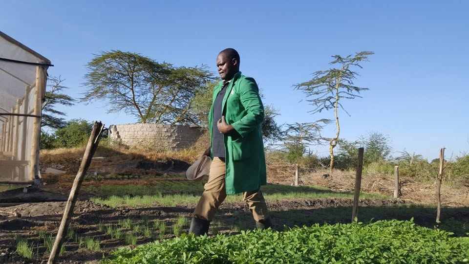 A farmer walking past a water tank on the farm